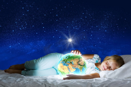晚安微信励志摄影照片_晚安。女孩躺在床上，手里拿着地球。这张图片的要素由美国宇航局提供