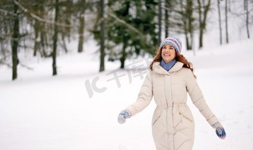 人，季节和休闲概念—愉快的微笑的妇女户外冬季森林。愉快的微笑的妇女户外在冬季森林