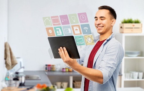 聪明的家，技术和人的概念—在厨房背景的愉快的年轻人片剂计算机快乐的年轻人与平板电脑在厨房