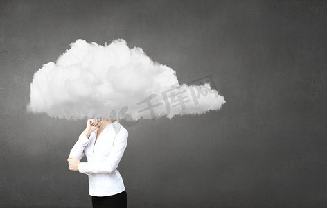 漂浮创意摄影照片_一位女商人站在那里，他的头在云中。漂浮在天空中
