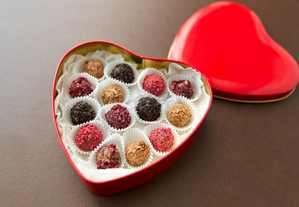 糖果，糖果和食物概念—糖果在红色心脏形状的巧克力盒在棕色背景糖果在红心形状巧克力盒