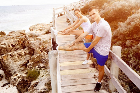 跑步者。一对年轻夫妇在海滩上锻炼和锻炼。跑步者。年轻夫妇一起在海滩上做运动