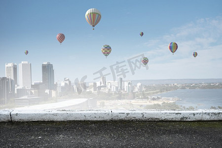 浮空器在城市上空飞行。五颜六色的浮空器飞行在晴朗的天空上面现代城市