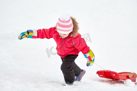童年、雪橇和季节概念-冬天带着雪橇爬雪山的快乐小女孩。冬天坐雪橇爬雪山的女孩
