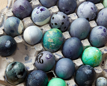 在托盘里涂了鸡蛋。复活节的海滩，平地。托盘里有漆蓝色的鸡蛋