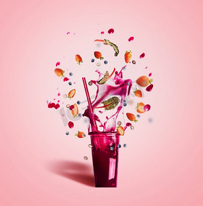 玻璃与饮用吸管和紫色飞溅夏天饮料：冰沙或果汁与飞行浆果成分在桃红色背景，前视图