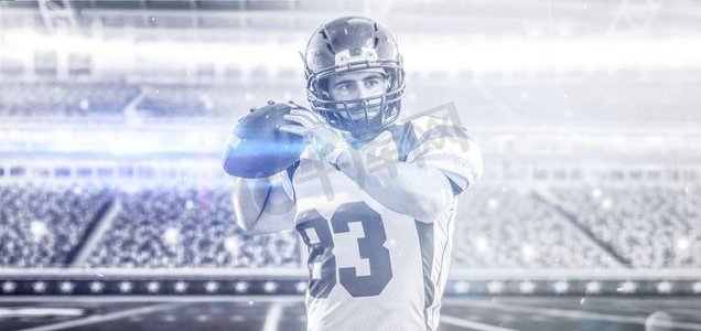灯光室内背景摄影照片_一名四分卫美式橄榄球运动员在灯光和照明弹的大型现代体育场上抛出孤立的球