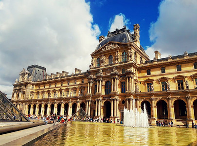 法国巴黎卢浮宫建筑的黎塞留翼，有喷泉、游客和玻璃金字塔。