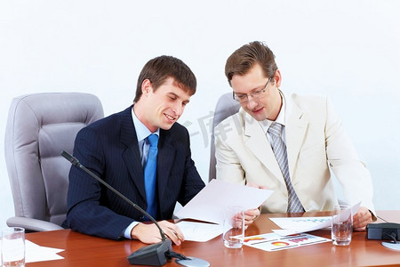 两个商人在见面。两位商人在会议上坐在桌子旁的形象