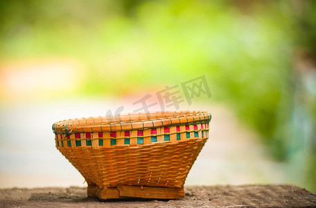 工艺品竹篮编织在老木与夏天自然绿色和黄色背景 