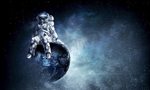 宇航员正坐在地球上。这张图片的元素由美国宇航局提供。身穿宇航服的宇航员在地球上。混合介质