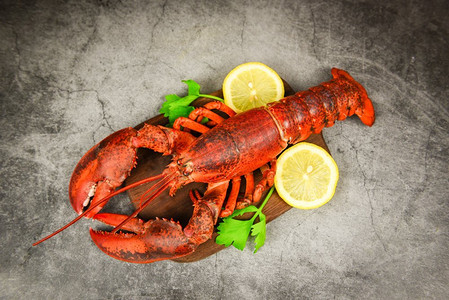 红龙虾配蔬菜和柠檬，木板和黑盘背景，俯瞰/龙虾晚餐