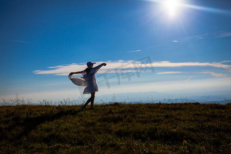 阳光与希望摄影照片_年轻的女孩与组织提出了，享受阳光在山顶上。女孩与自然的统一