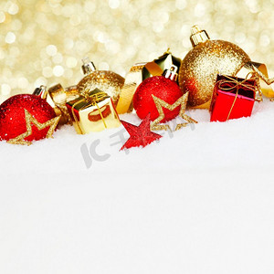 红色和金色的圣诞球和装饰在雪