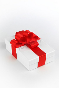 蝴蝶结摄影照片_一个白色礼品盒与红色蝴蝶结白色背景