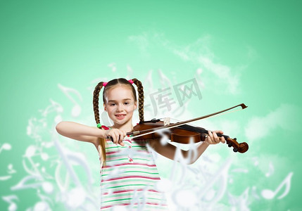 女孩拉小提琴。可爱的女孩拉小提琴的形象反对绿色背景