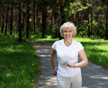 一位老妇人喜欢在公园里跑步。健康的生活方式