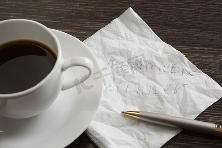 餐巾纸上的爱情告白。浪漫的消息写在餐巾和一杯咖啡在木桌