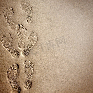 沙滩背景摄影照片_沙子上的脚印。沙滩背景，沙滩上有脚印