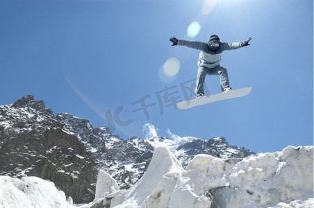 单板滑雪运动。单板滑雪运动员在晴朗的蓝天中跳高