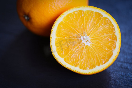 新鲜的橙色水果片半在黑暗的背景 