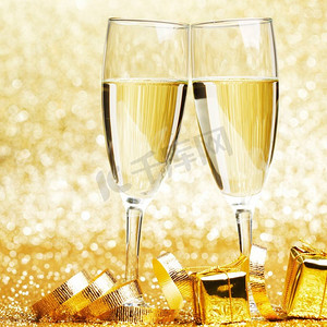 金色闪光摄影照片_一杯香槟酒和金色闪光的丝带