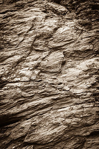 石壁背景摄影照片_背景天然石材，墙体纹理粗糙，岩石表面粗糙。石壁纹理背景粗糙的岩石表面