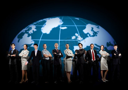 世界地图摄影照片_一群商人。一群商人站在一起反对世界地图背景