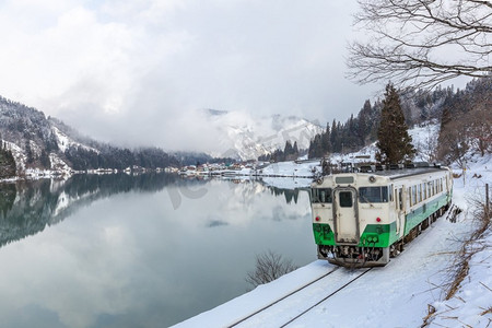 与冬季风景雪和湖上村庄一起训练