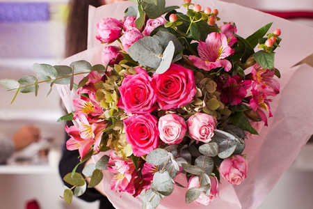 花商制作粉色花束的时尚花束。花商用玫瑰制作花束