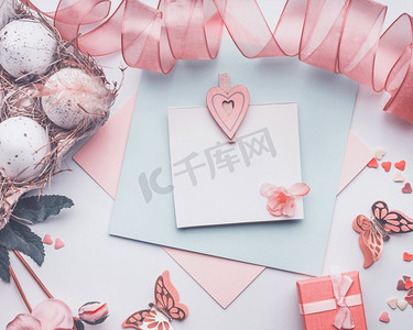 粉色彩带背景摄影照片_可爱的复活节贺卡，粉色，彩带，礼品盒和装饰品，顶视