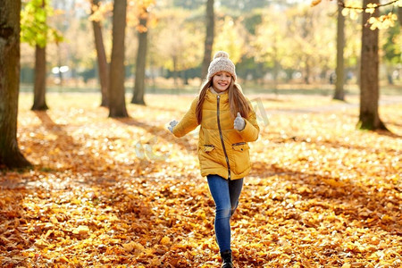 童年，季节和人的概念—快乐的女孩运行在秋天公园。快乐的女孩运行在秋天公园