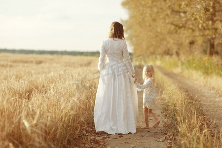 一个女孩和她的母亲在秋天的田野里