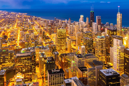 伊利奶粉摄影照片_日落鸟瞰美国伊利诺伊州芝加哥市中心的芝加哥天际线建筑和密歇根湖。
