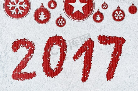 关于雪的新年背景。圣诞卡或新年背景，由手写在雪地和红色工艺纸上的圣诞符号制成