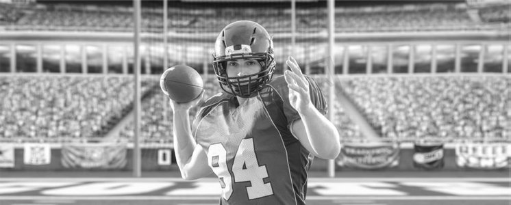一名四分卫美式橄榄球运动员在灯光和照明弹的大型现代体育场投球