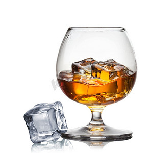在白色背景的玻璃杯中洒上威士忌加冰块
