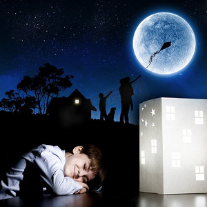 舒适睡眠摄影照片_晚上做梦。可爱的小男孩睡觉和梦想回家