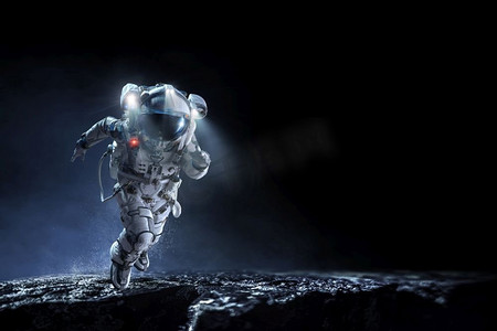 宇航员星球摄影照片_穿着宇航服的宇航员在行星表面运行。混合媒体。太空人跑得很快。混合媒体