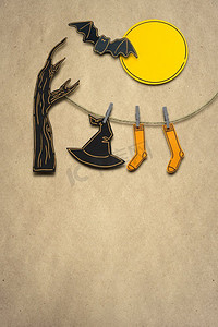 创造性的万圣节概念照片，女巫的帽子和长筒袜纸制成的棕色背景。