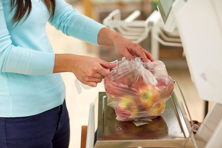 购物,销售,消费主义和人的概念-女人在杂货店称苹果.