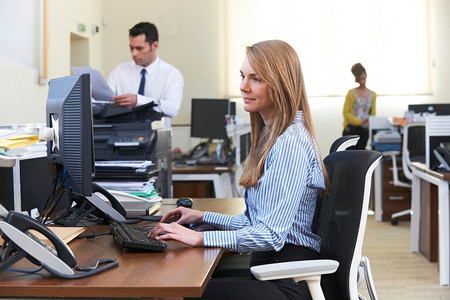 女商人工作在计算机在繁忙的办公室