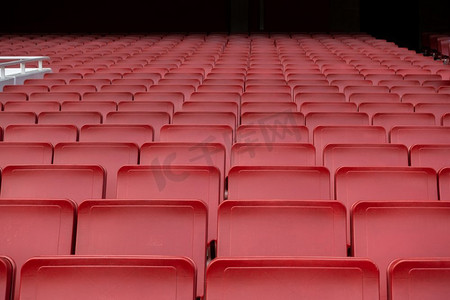 座位席位摄影照片_空的红色座位排在足球场足球