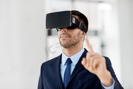 商业，技术和增强现实概念—商人与虚拟现实耳机在办公室。商人在办公室与虚拟现实耳机