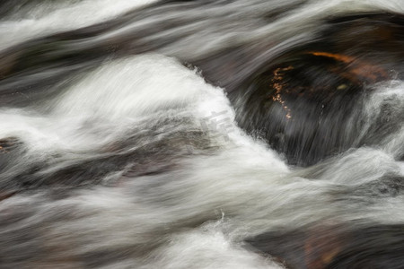 详细景观图像的河流流过岩石与长曝光运动模糊