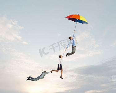 逃离办公室。商务人士撑着伞在天空中飞翔