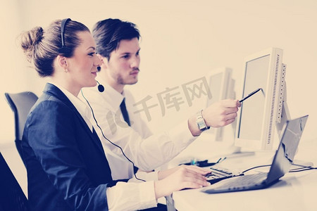 带耳机的商务人员小组在帮助台办公室为客户提供支持,经理提供培训和