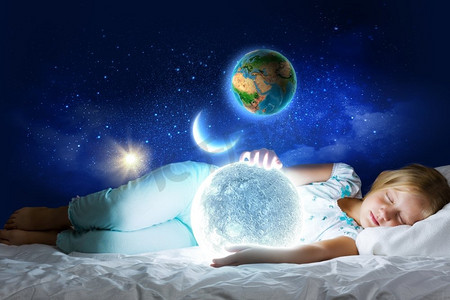 晚安。女孩躺在床上，手里拿着月亮。这张图片的要素由美国宇航局提供