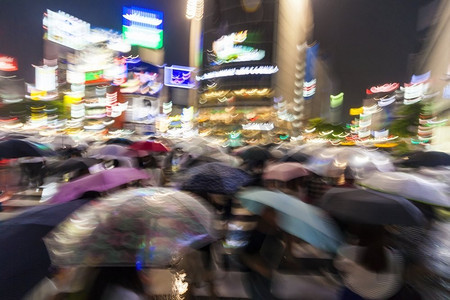 在涩谷十字路口，日本东京，在雨中，人们打着雨伞，
