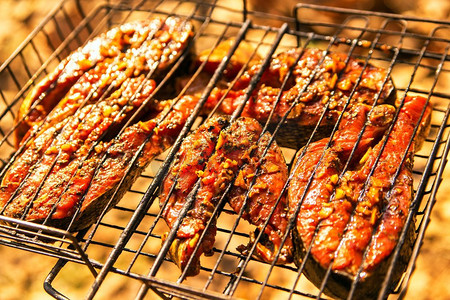 生姜出土摄影照片_烤鲑鱼排和生姜腌汁在烤架上。顶视图烤鲑鱼在燃烧的braai